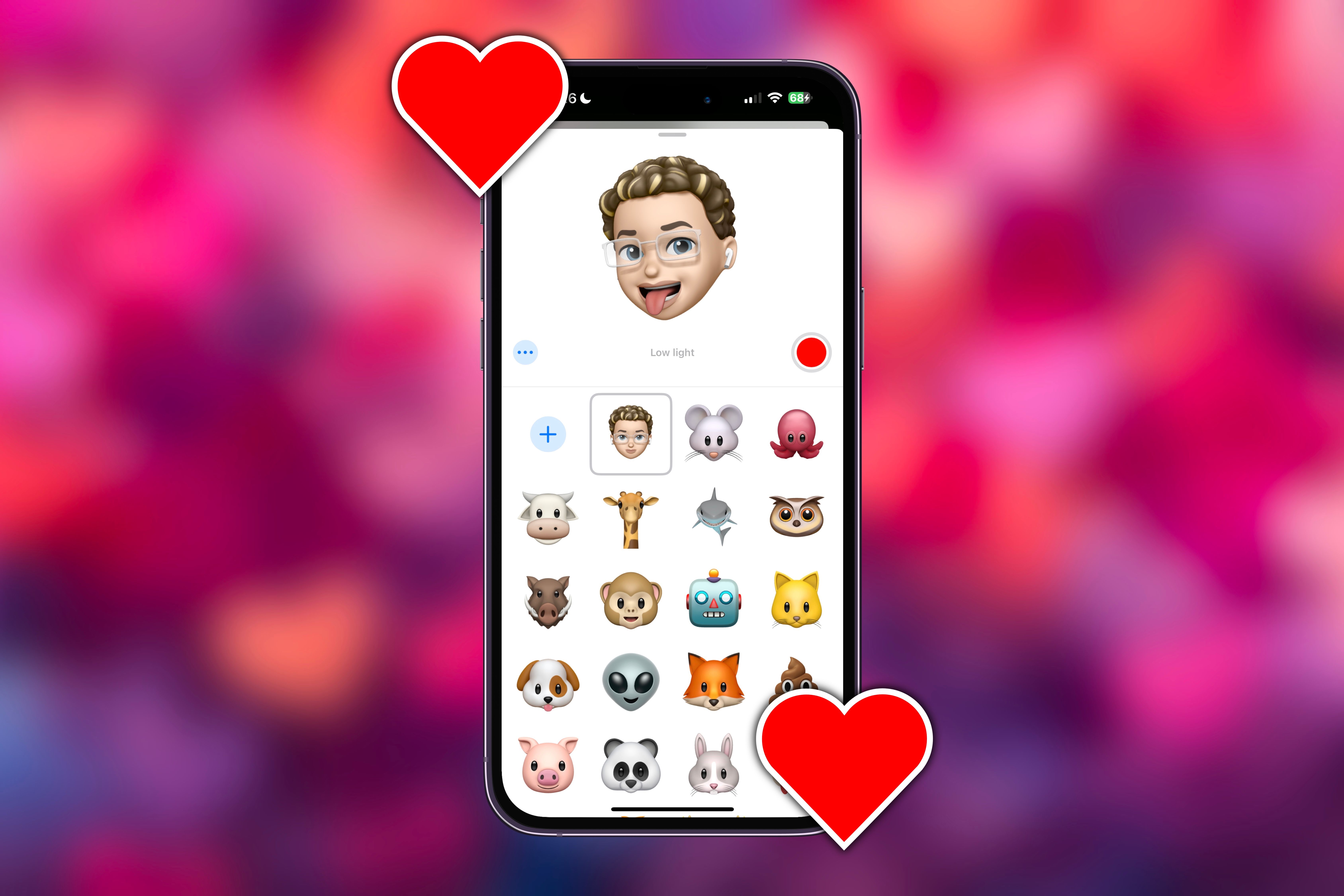 Creating a Memoji video in iMessage on an iPhone surrounded by hearts.