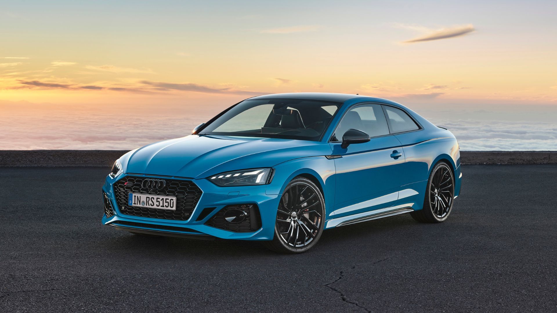 Blue Audi RS5 Coupé parked on an angle on a beach.