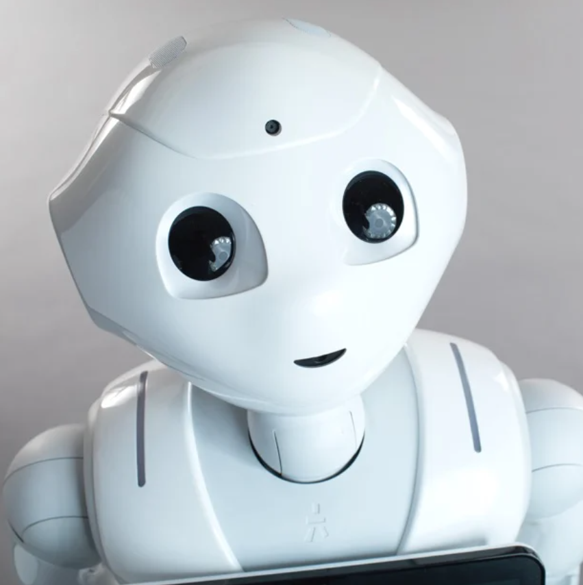 Pepper, a robot with rounded head, big eyes, and a tablet display on its chest.