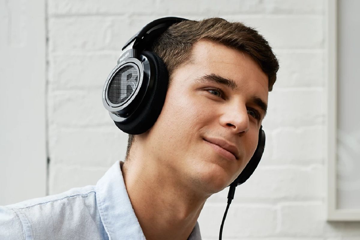 Philips Audio SHP9500 headphones being worn by a person, slightly smiling