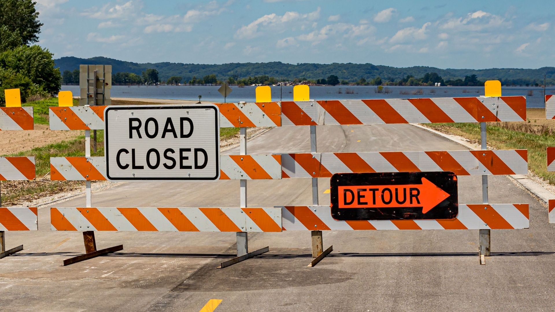 A brightly colored detour sign indicating a road closure.