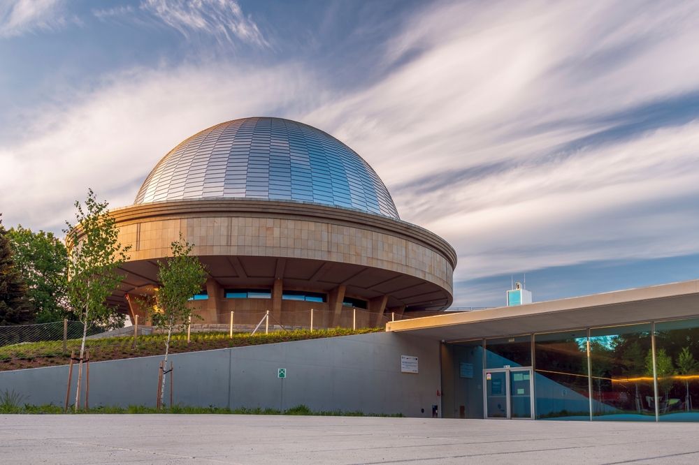 Chorzów, Poland - May 23, 2022: Silesian planetarium after renovation. The dome of the Silesian planetarium shining in the light of the setting sun. Aluminum panels on the roof .