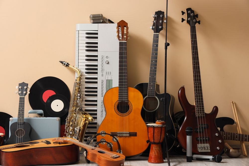 Different musical instruments near beige wall.