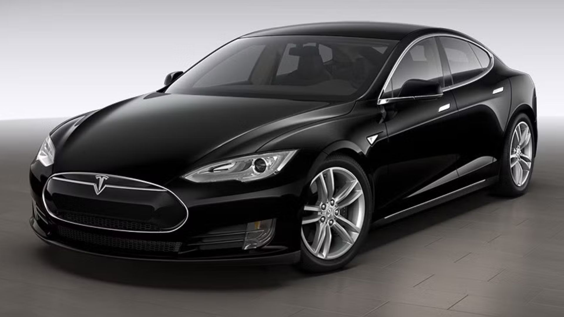 Front three-quarter view of a black 2015 Tesla Model S parked in a studio.