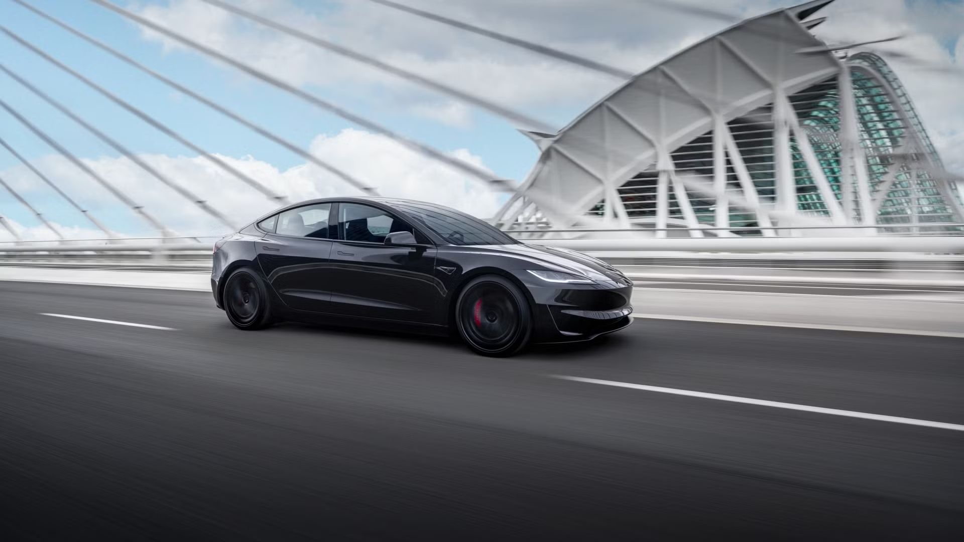 Photo of the 2024 Tesla Model 3 performance driving over a bridge