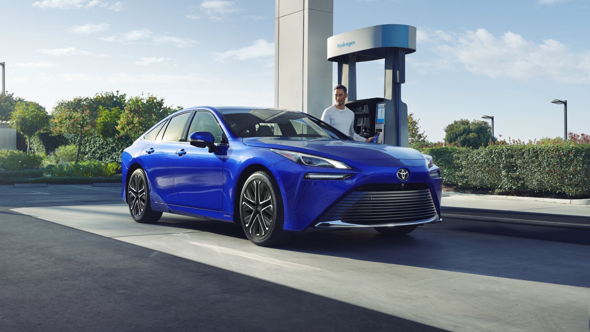 Full view of a blue 2024 Toyota Mirai being refueled at a hydrogen station. 