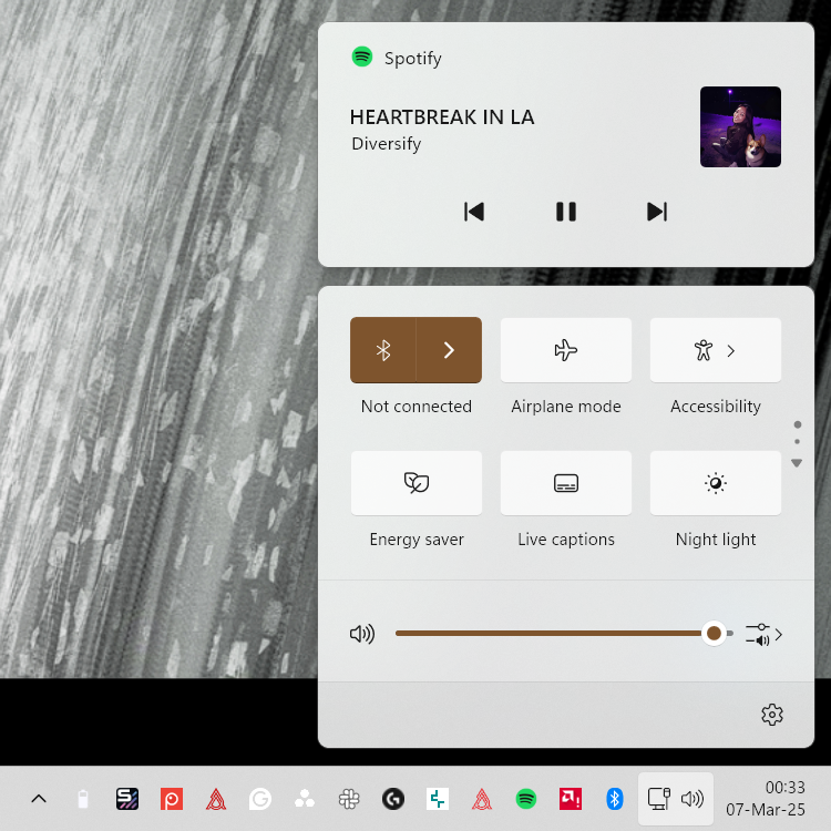 A screenshot of the Windows 11 Action Center with Spotify playing.