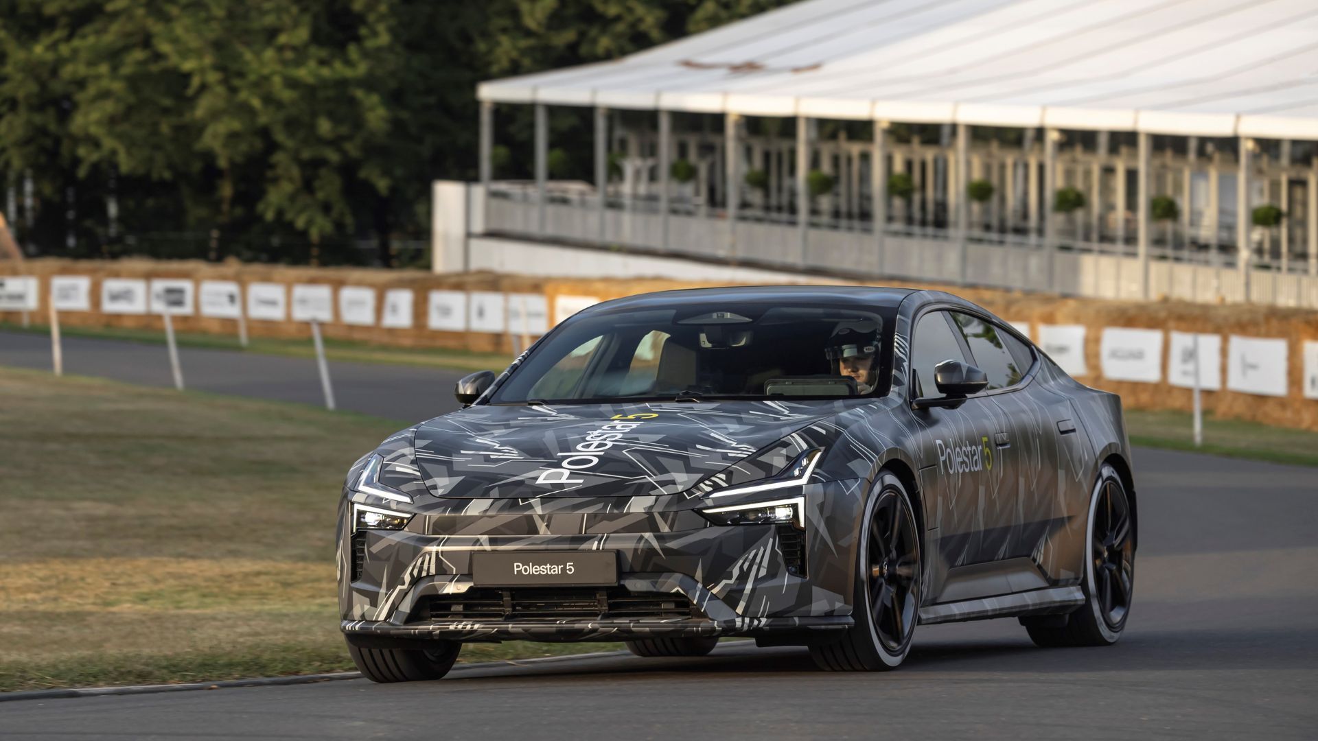 Full view of a camoflaged Polestar 5 Prototype pictured on track at 2023 Goodwood Festival of Speed.