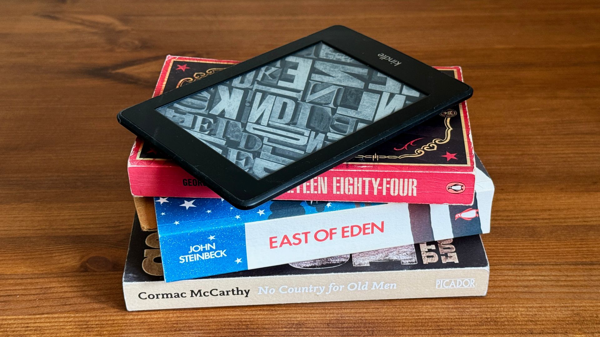 A stack of books with a Kindle eReader on top of them.