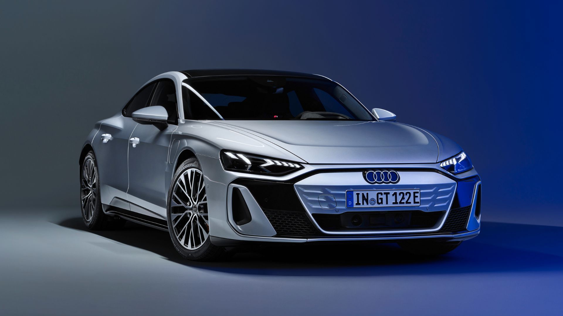 Full view of a silver Audi e-tron GT pictured in a studio setting.