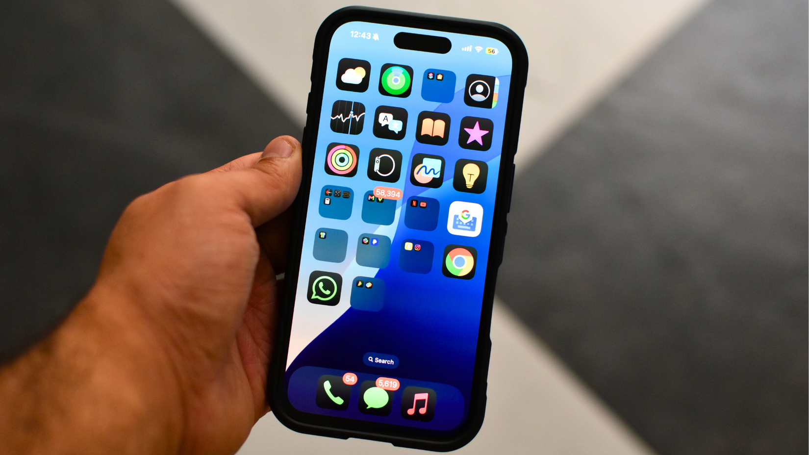 На экране iPhone тёмные обои и лаконичные иконки приложений.
