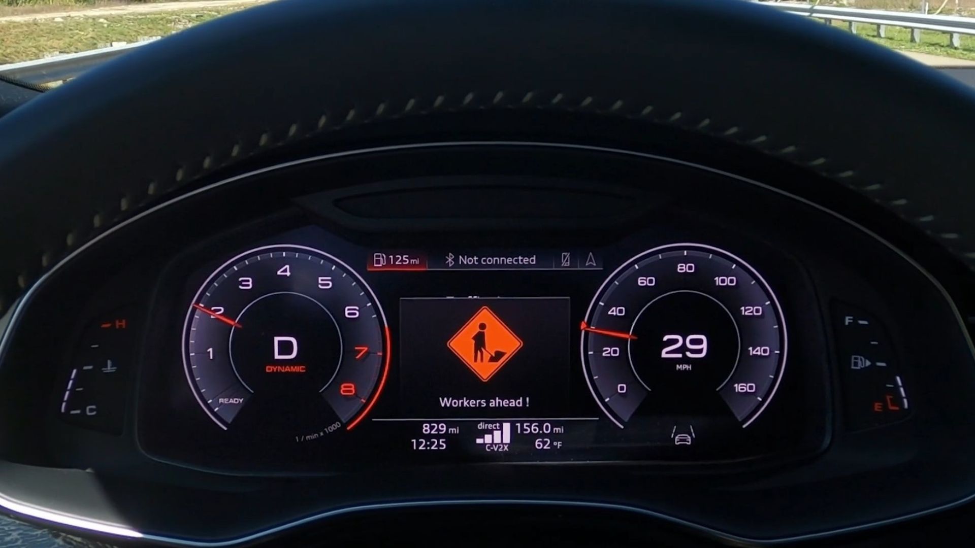 Close up of the digital cluster of an Audi showing that there are workers in the road ahead.
