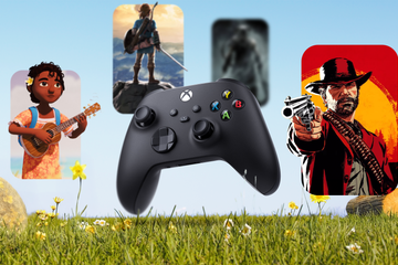 A video game controller on grass with a few games in the background.