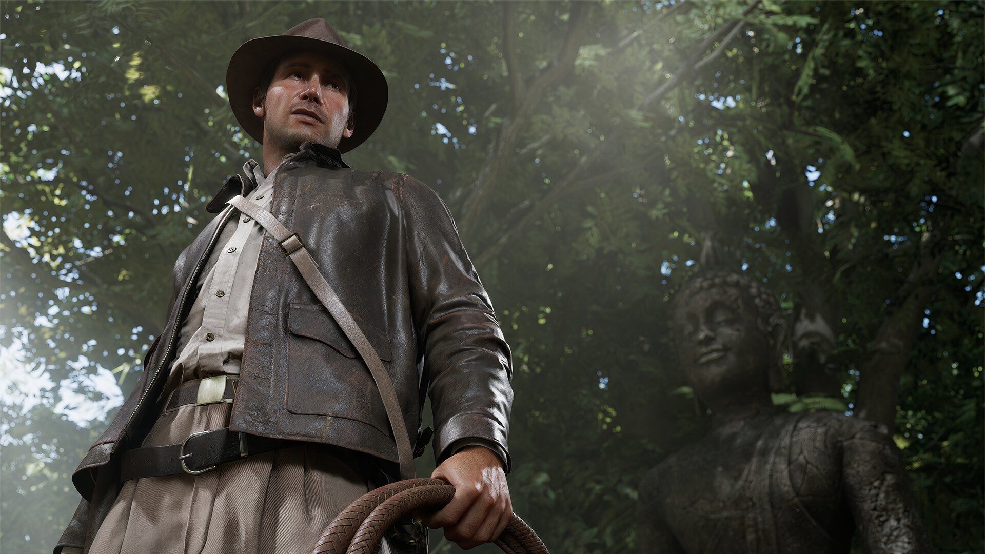 Indiana Jones standing tall beside a statue.