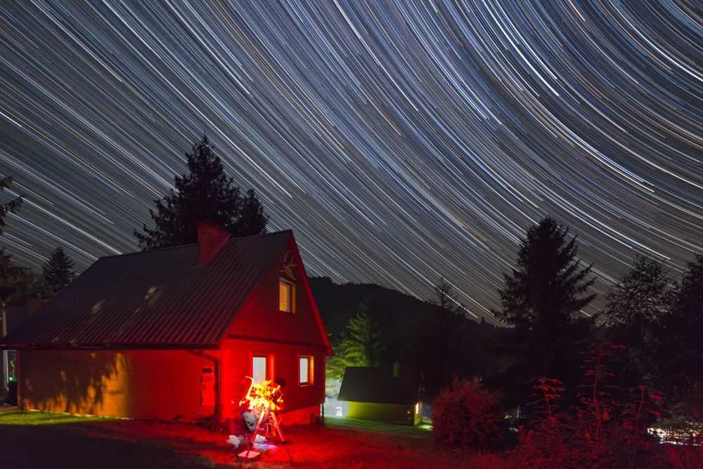 An astrophotographer using a red light with their telescope. 