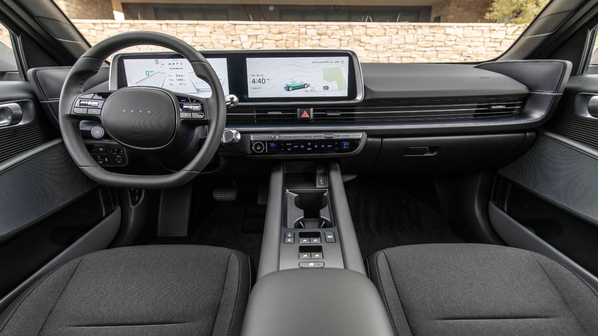 Close-up shot of the dashboard in the 2025 Hyundai Ioniq 6 SE showing the front seats, steering wheel, and infotainment displays.
