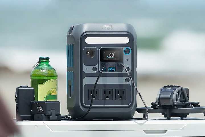 The Anker Solix C300 power station on a table charging several devices simultaneously.