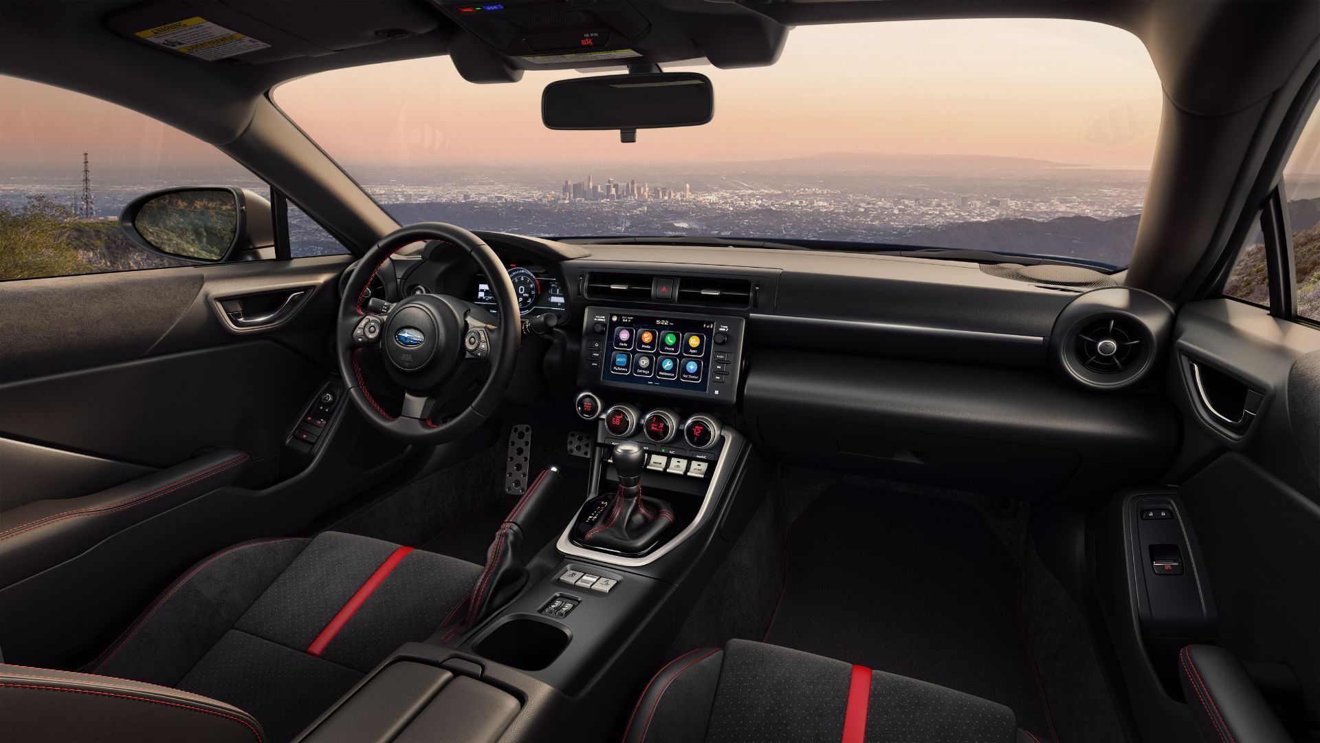 Shot of inside the cabin of a 2024 Subaru BRZ, showing the front setas, steering wheel, infotainment screen, and center console.