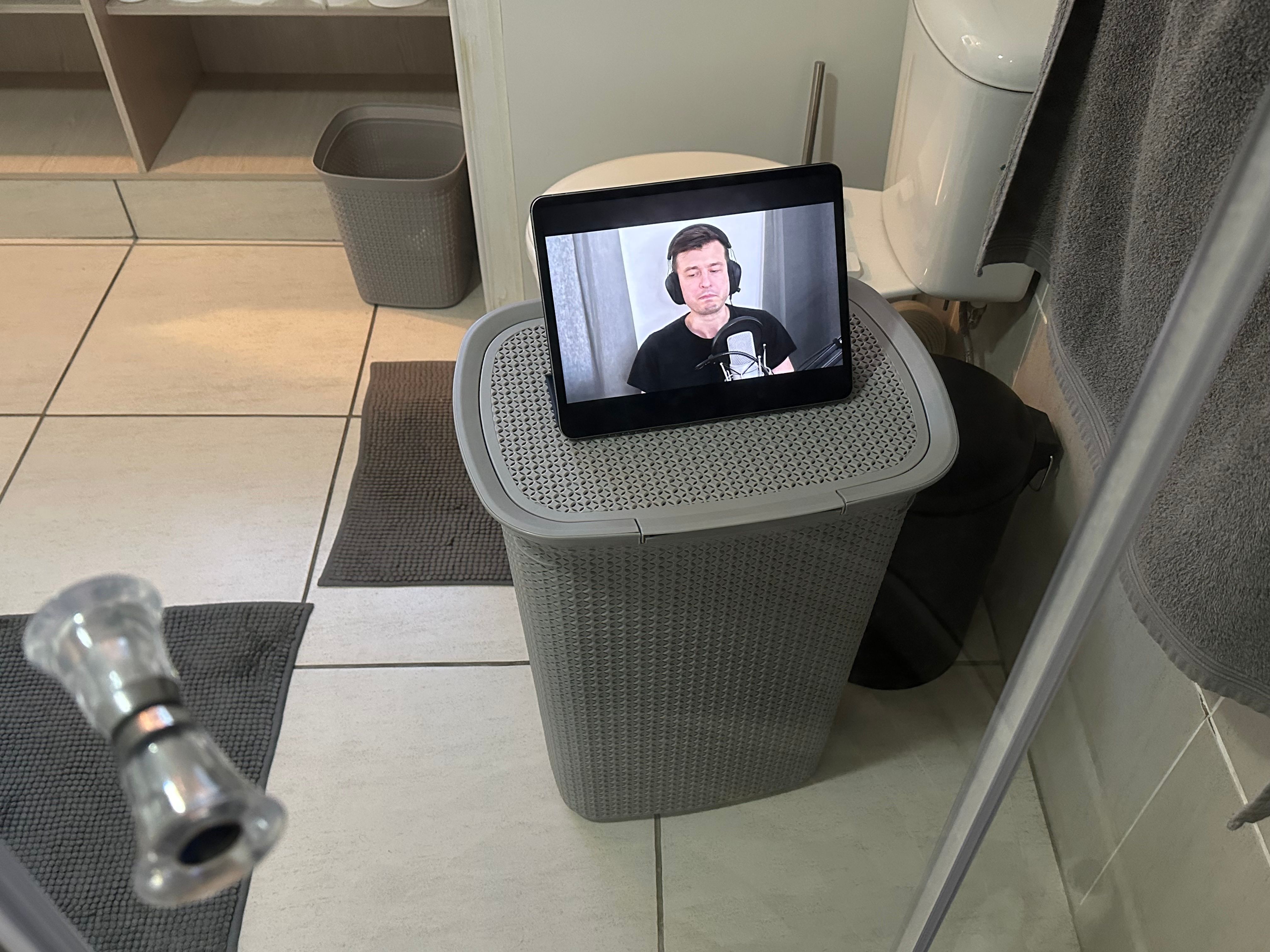 A YouTube video playing on an iPad visible through a shower door.