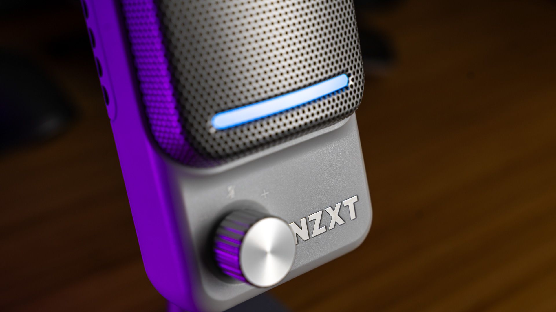 A side shot of the NZXT Capsule Elite microphone showing the gain knob, light bar, and logo.