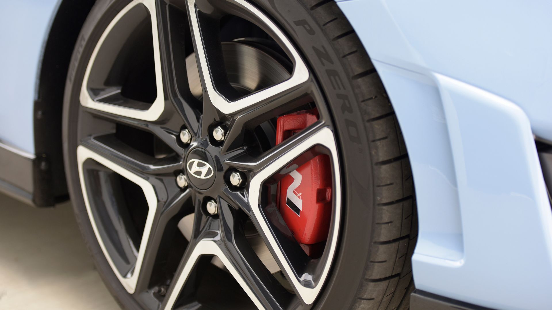 Close-up shot of the alloy wheel on a blue 2022 Hyundai Veloster N.