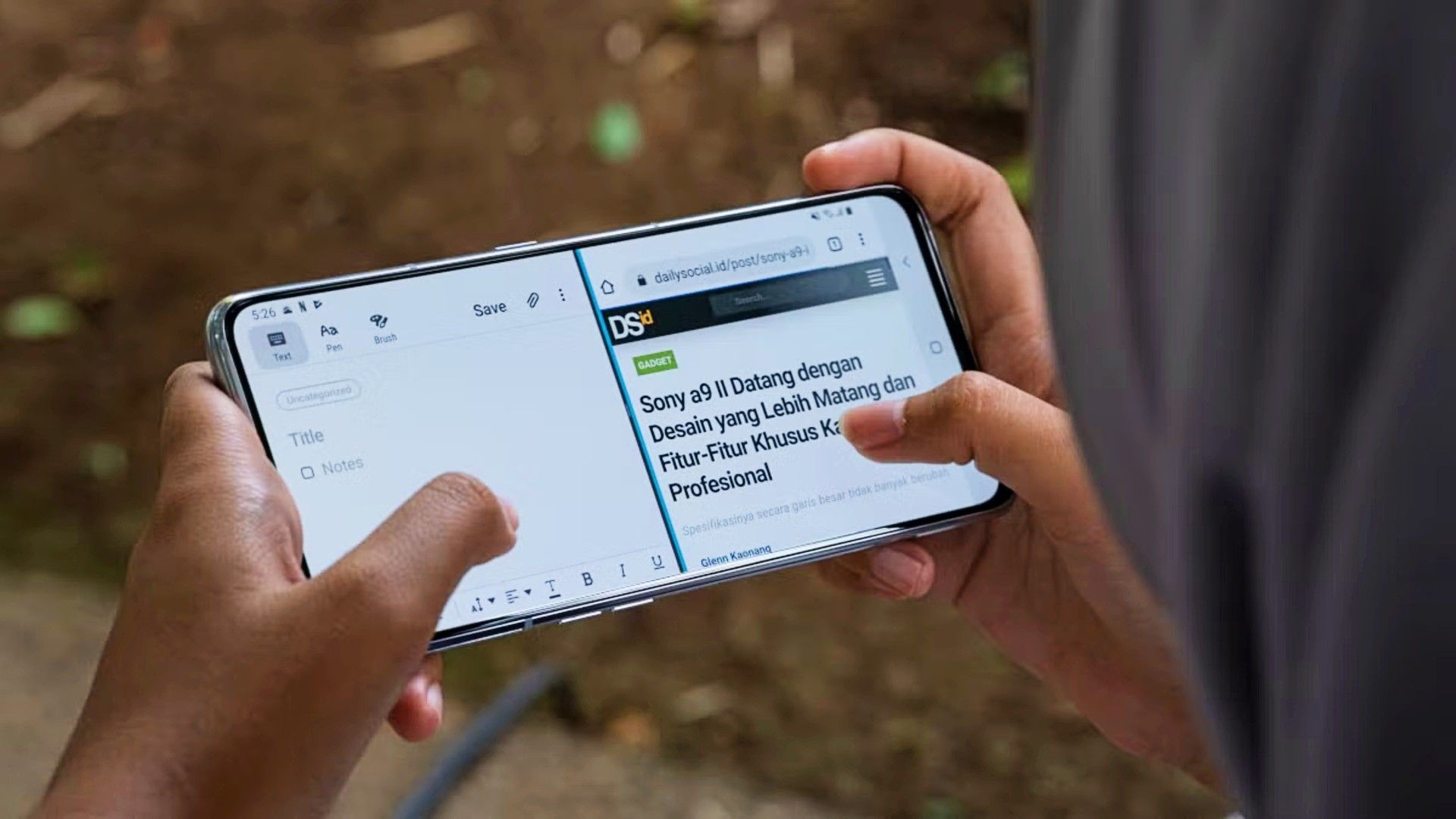 Person's hands holding an Android phone and using it in split-screen mode.