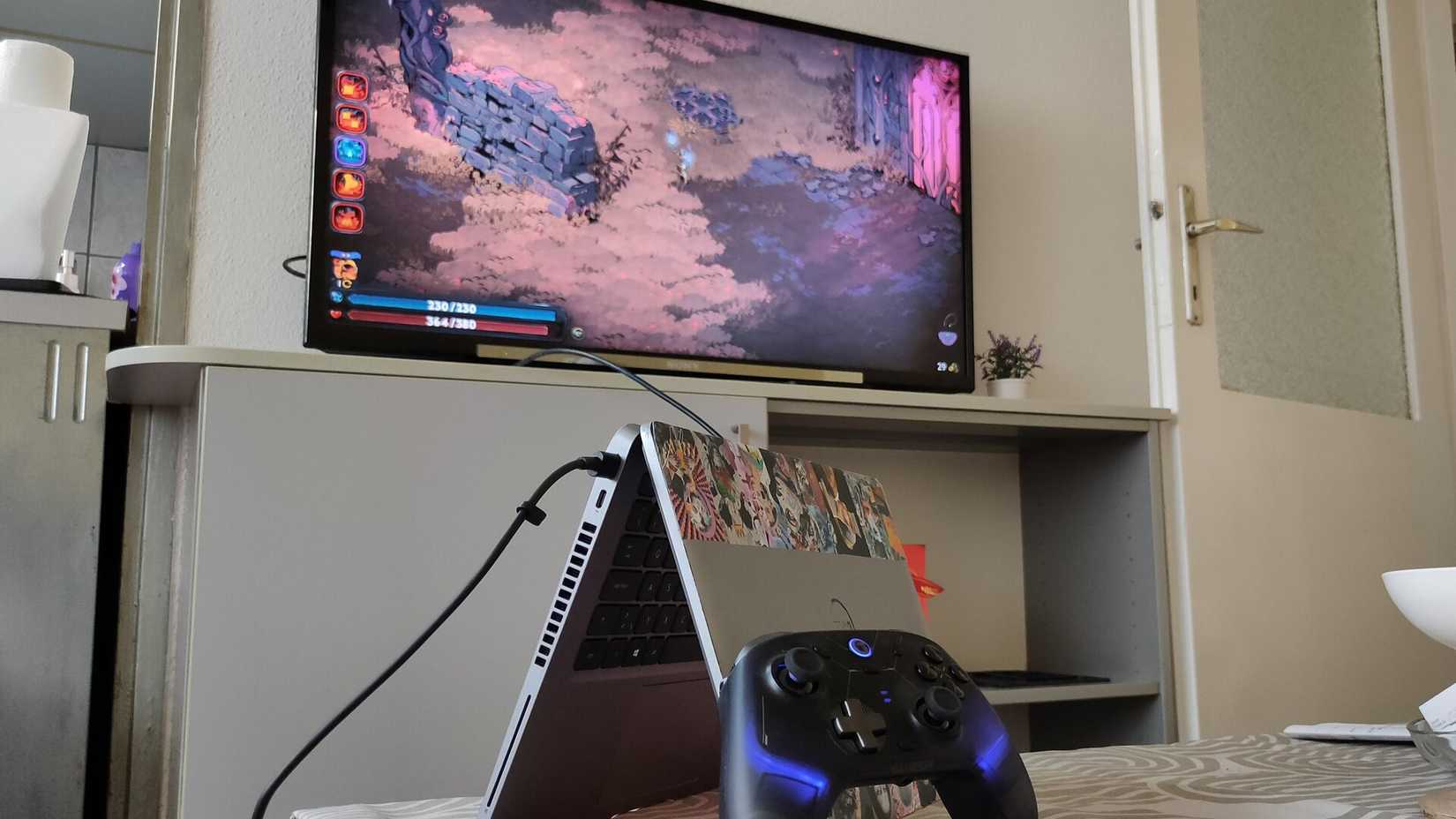 A tented Dell laptop with a controller hooked up to a TV.