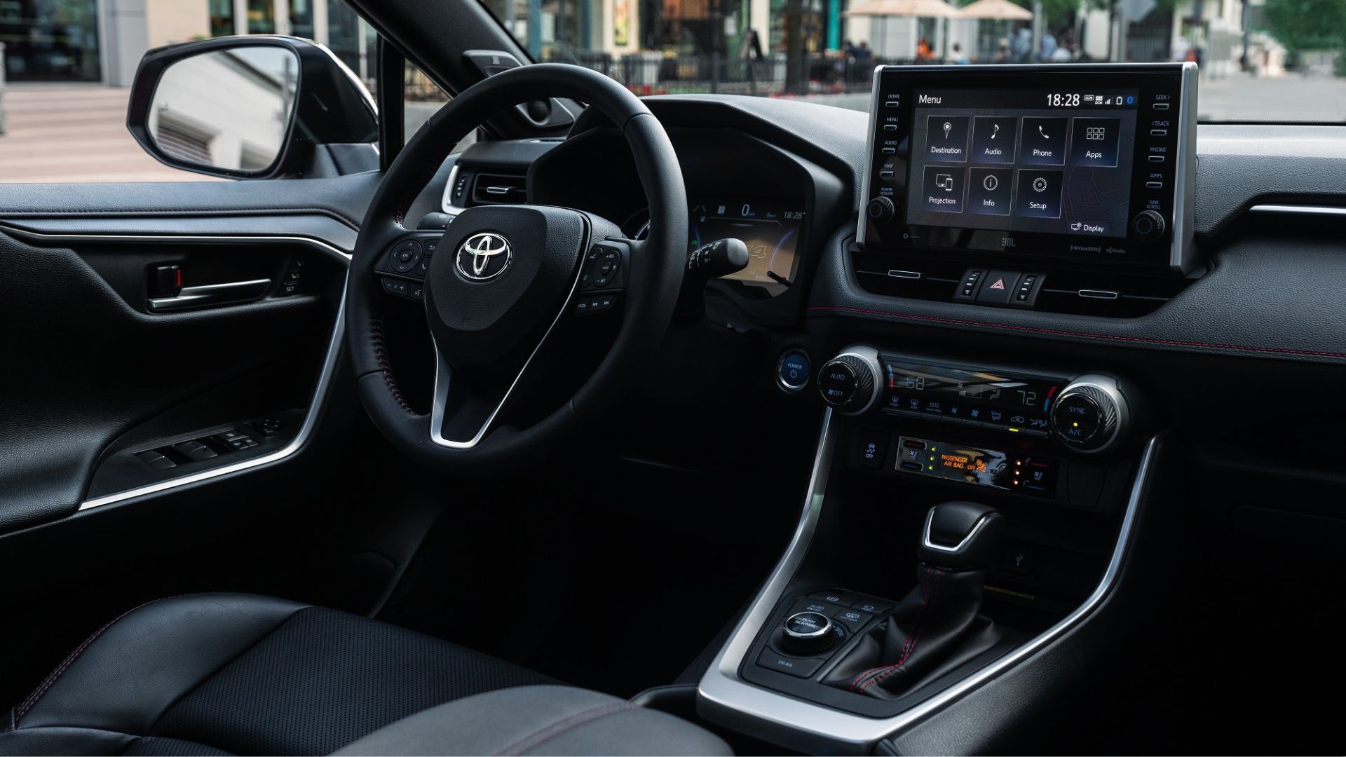 Close-up shot of the interior of the 2023 Toyota RAV4 Prime XSE, showing the driver's seat, steering wheel, and infotainment screen.