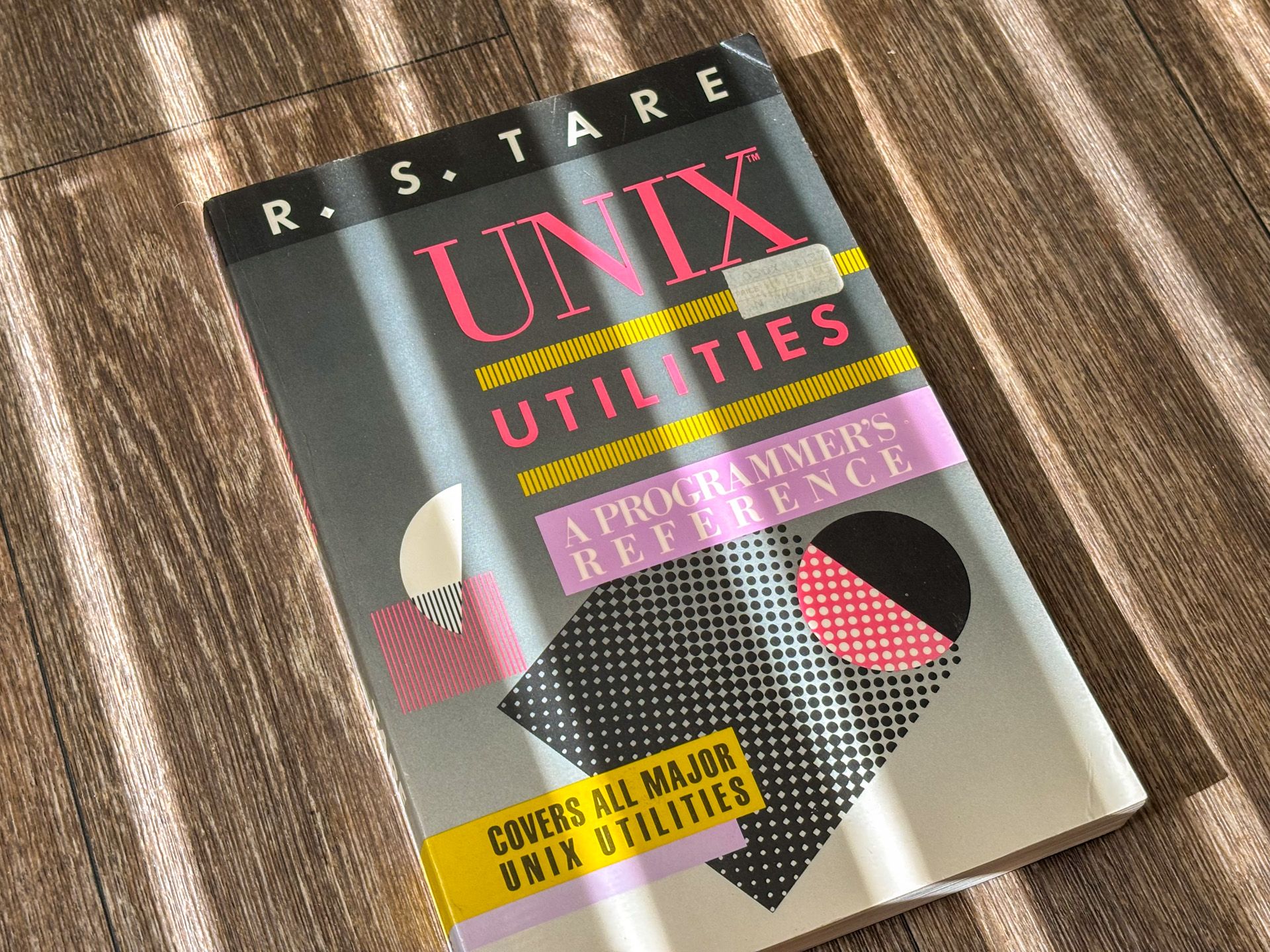 A book entitled "UNIX Utility" By RS Tare, with a vintage design with geometric shapes.