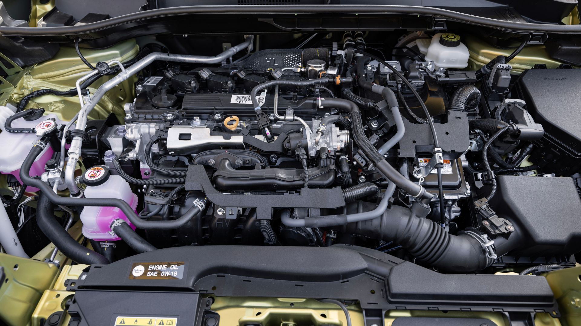 2024 Toyota Corolla Cross Hybrid shows a close-up shot under the hood of the Hybrid XSE, showing a 2.0-liter inline-4 engine with a battery pack.
