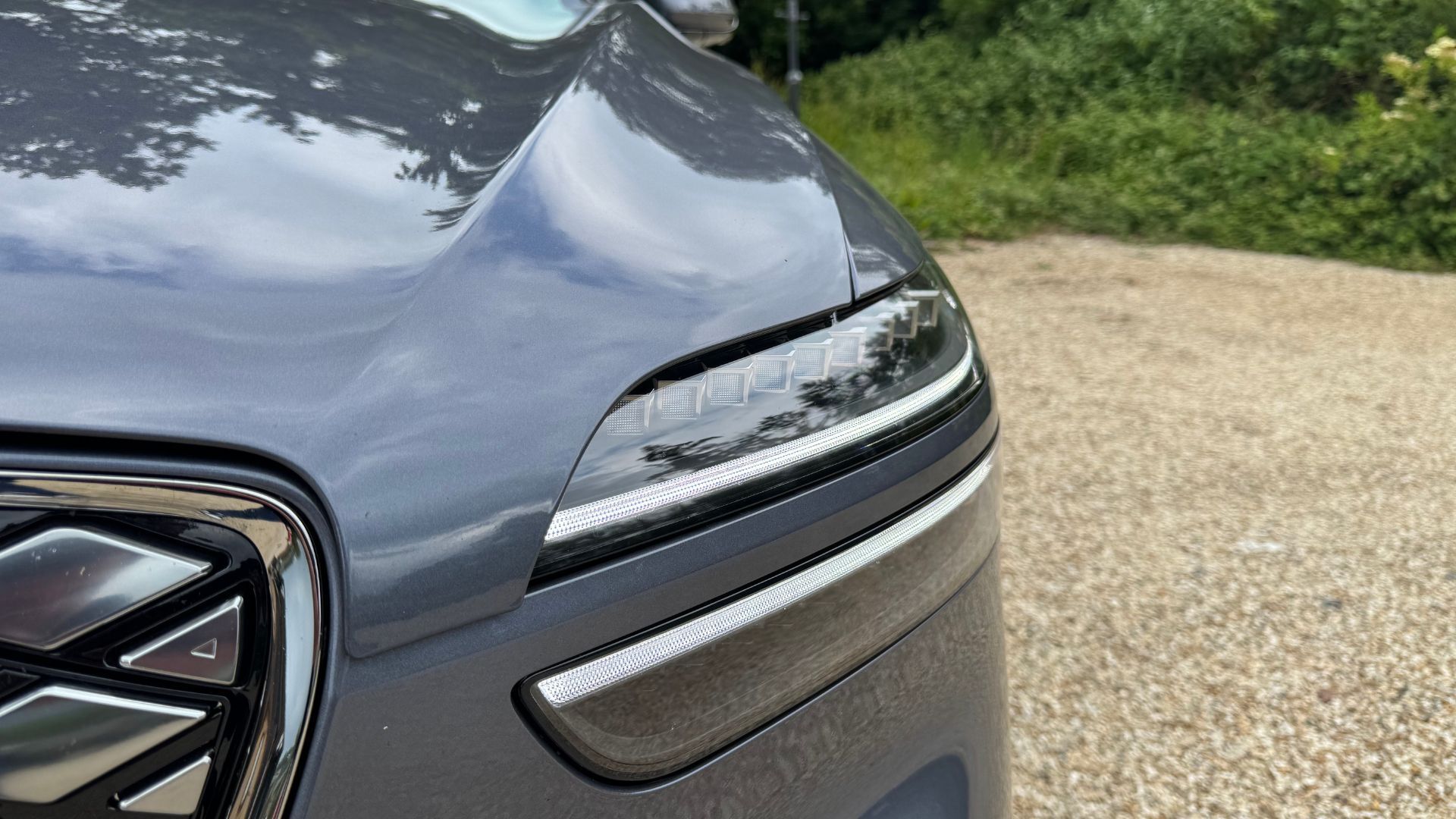 Close-up shot of the LED headlight on a gray 2026 Genesis Electrified GV70.