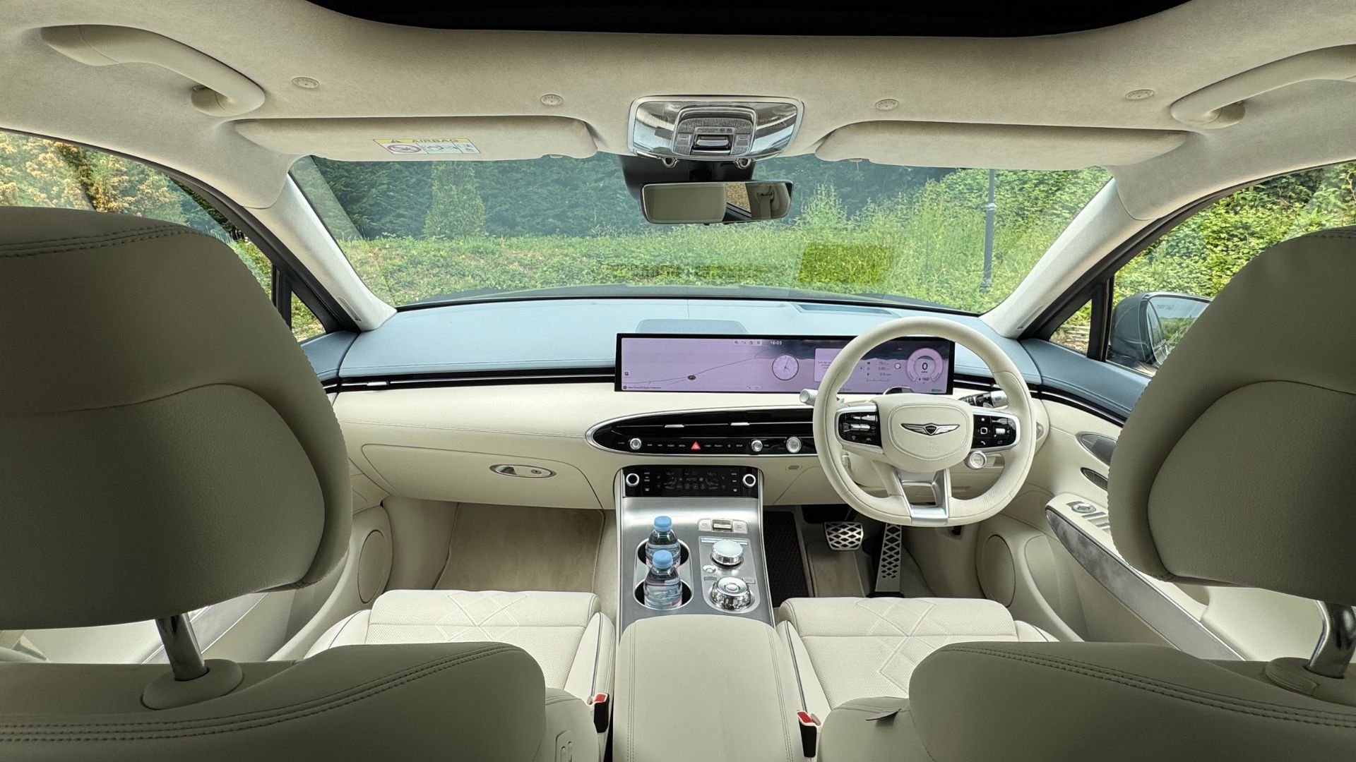 Shot inside the cabin of a 2026 Genesis Electrified GV70 showing the cream leather seats.