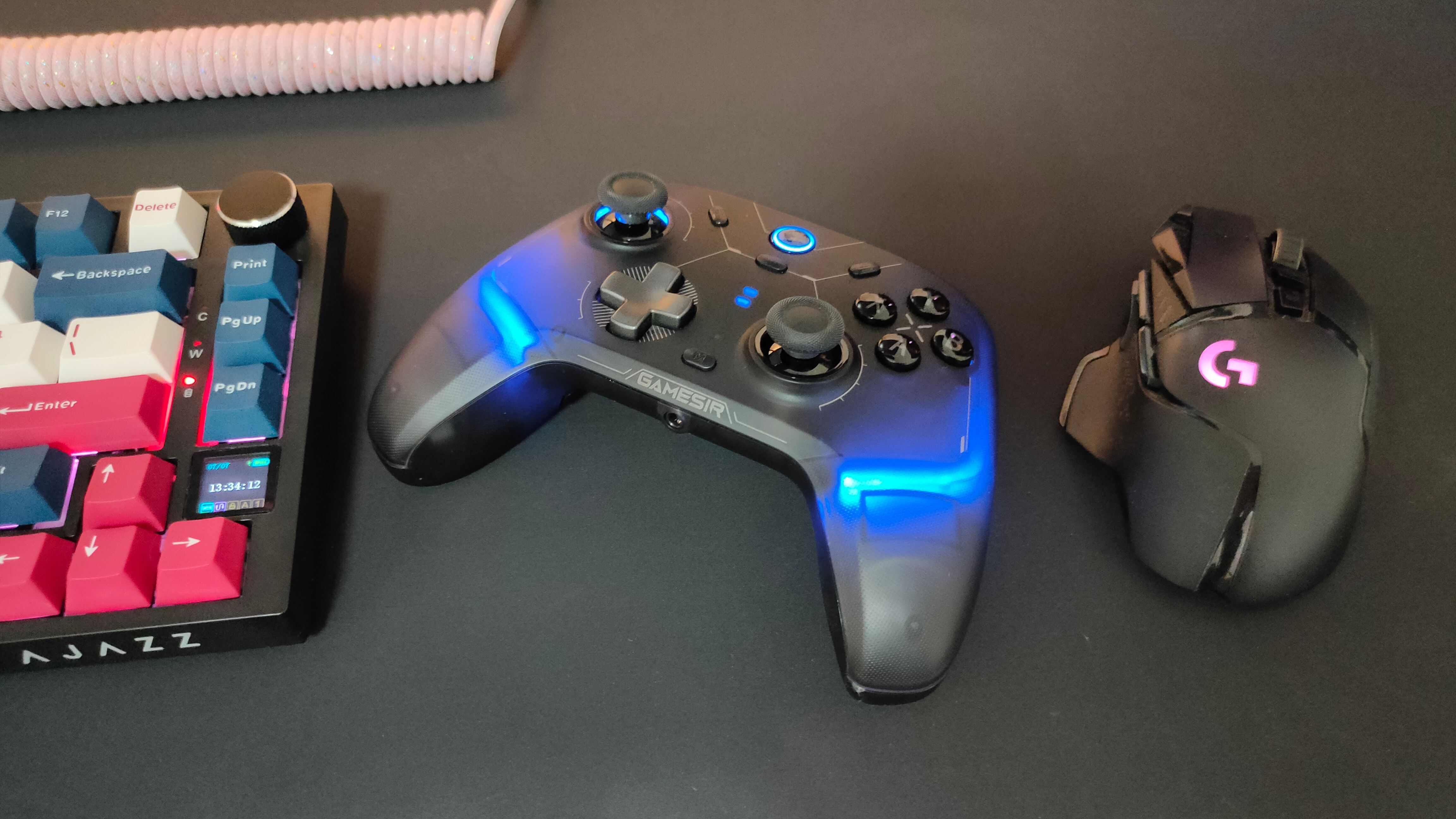 The GameSir Cyclone 2 controller between a Logitech G502 mouse and mechanical keyboard.
