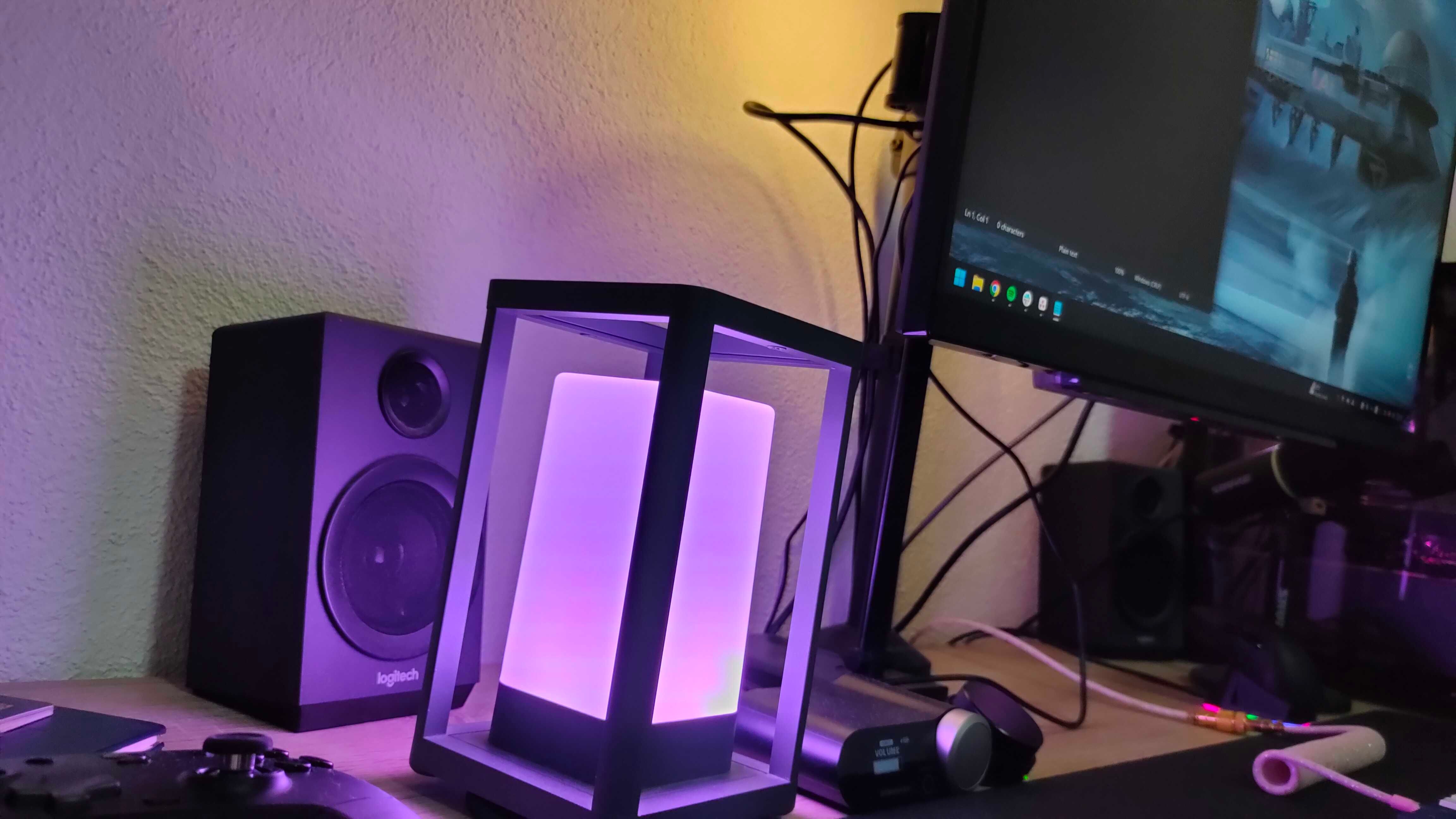 A pink smart lamp glowing on a desk.