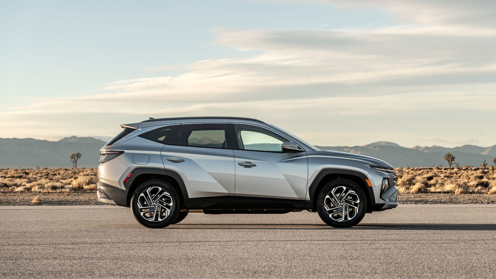Hyundai Tucson PHEV 2025 сбоку на фоне гор.