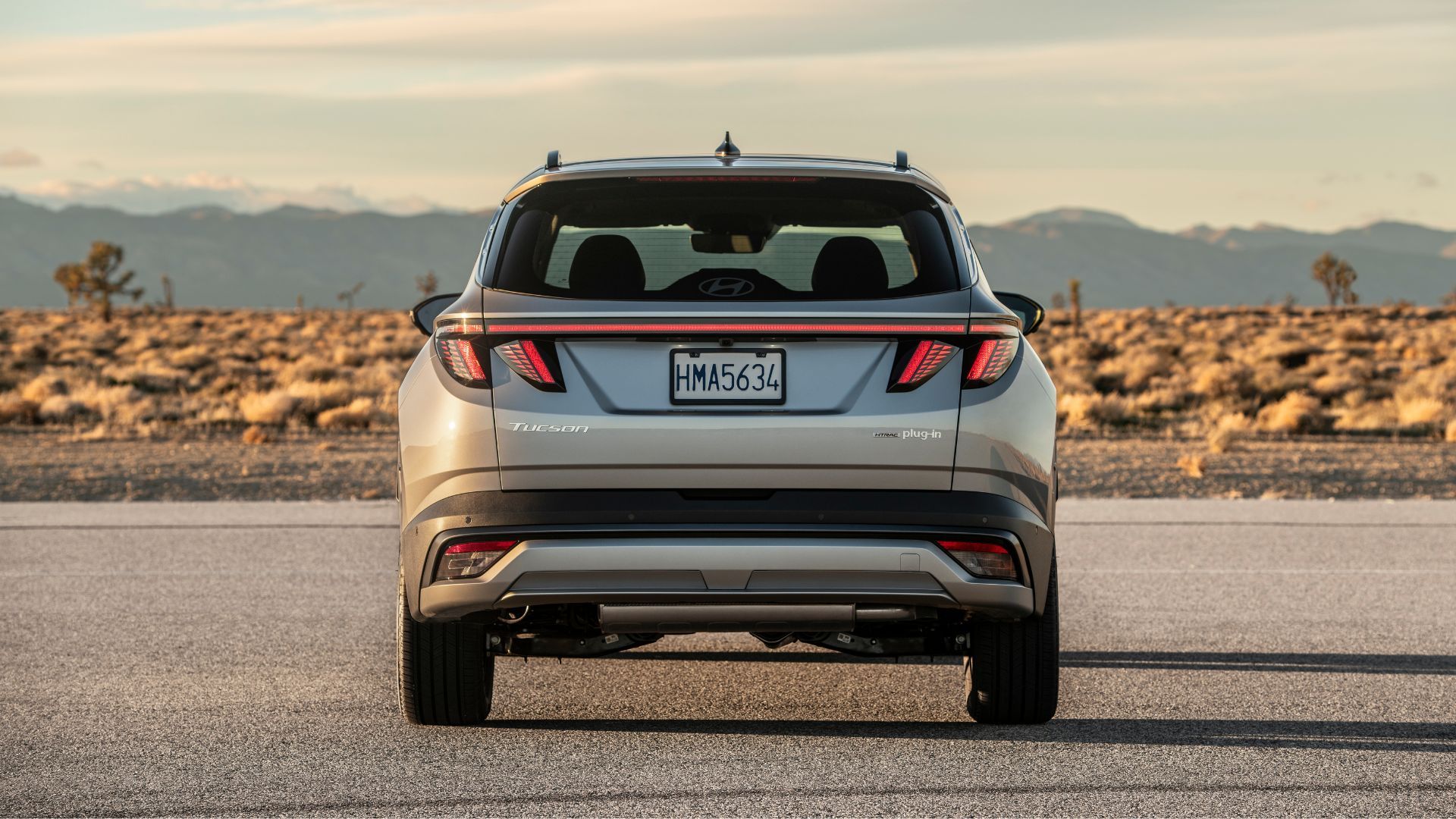 A gray 2025 Hyundai Tuxon Phev's static rear-end of a shot of PHEV was parked on the Turmac with the mountains.
