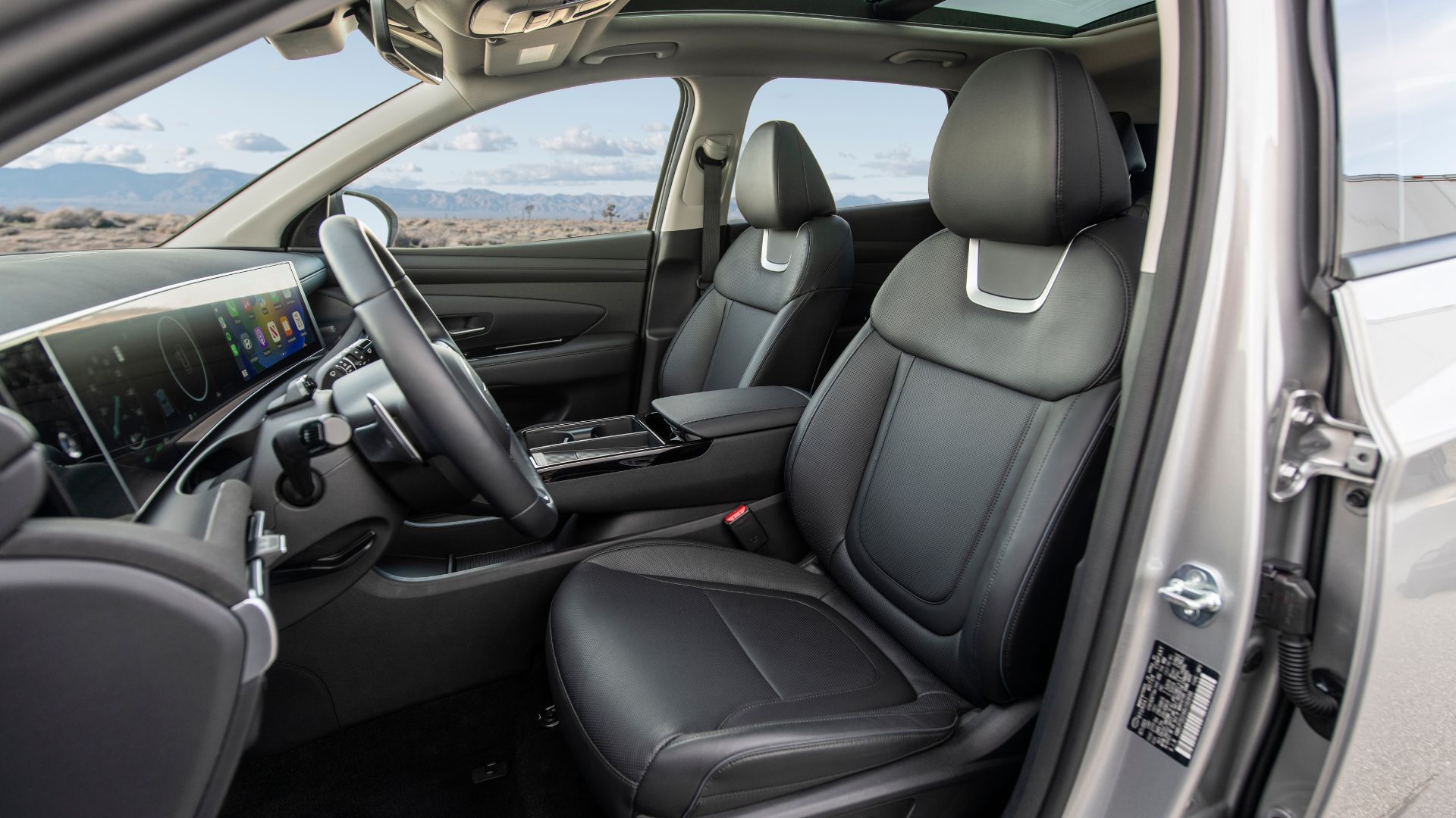 Крупный план передних сидений из чёрной кожи Hyundai Tucson PHEV 2025.