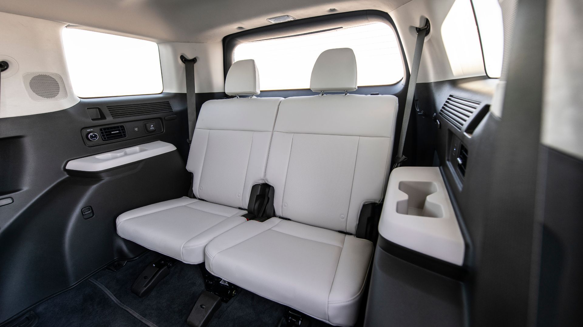 Close-up shot inside the cabin of a 2025 Hyundai Santa Fe Hybrid, showing the third row seats covered in white leather.