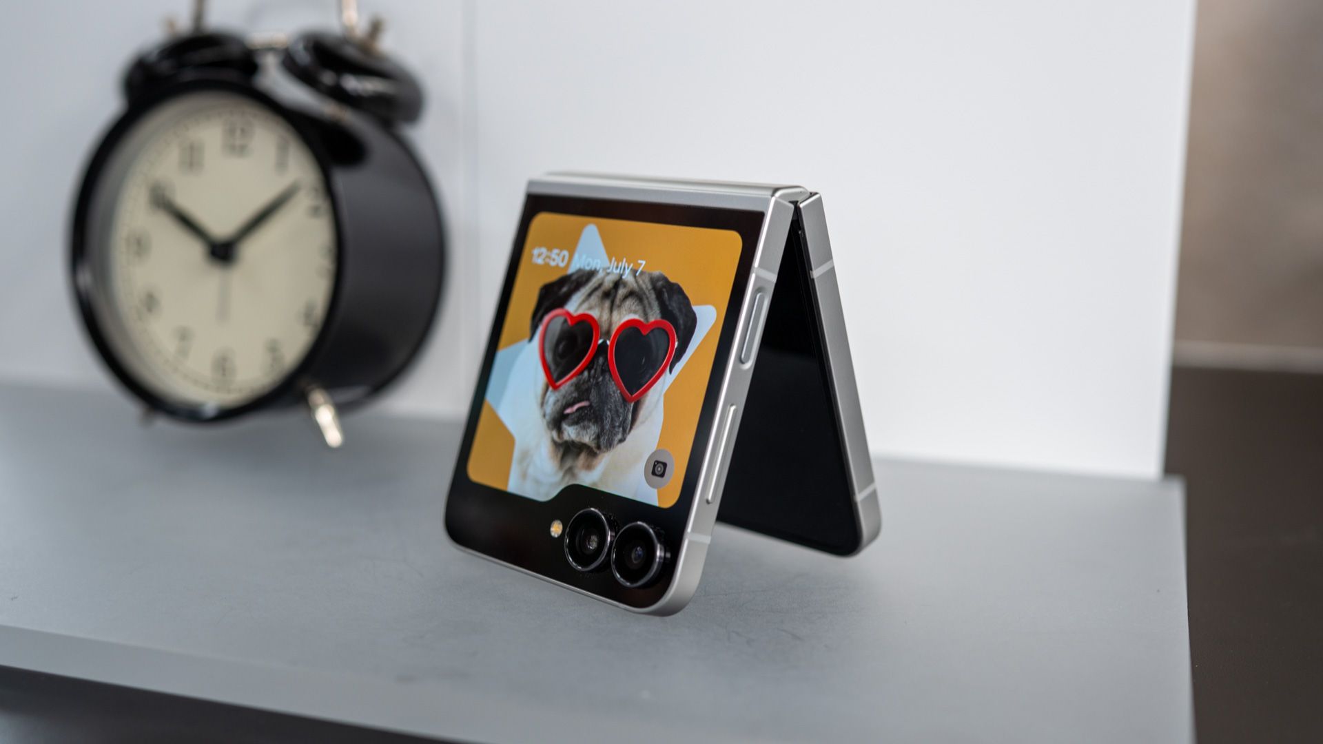 Samsung Galaxy Z Flip 7 Fe assis sur une table avec l'affichage de la couverture sur 54641202522 O