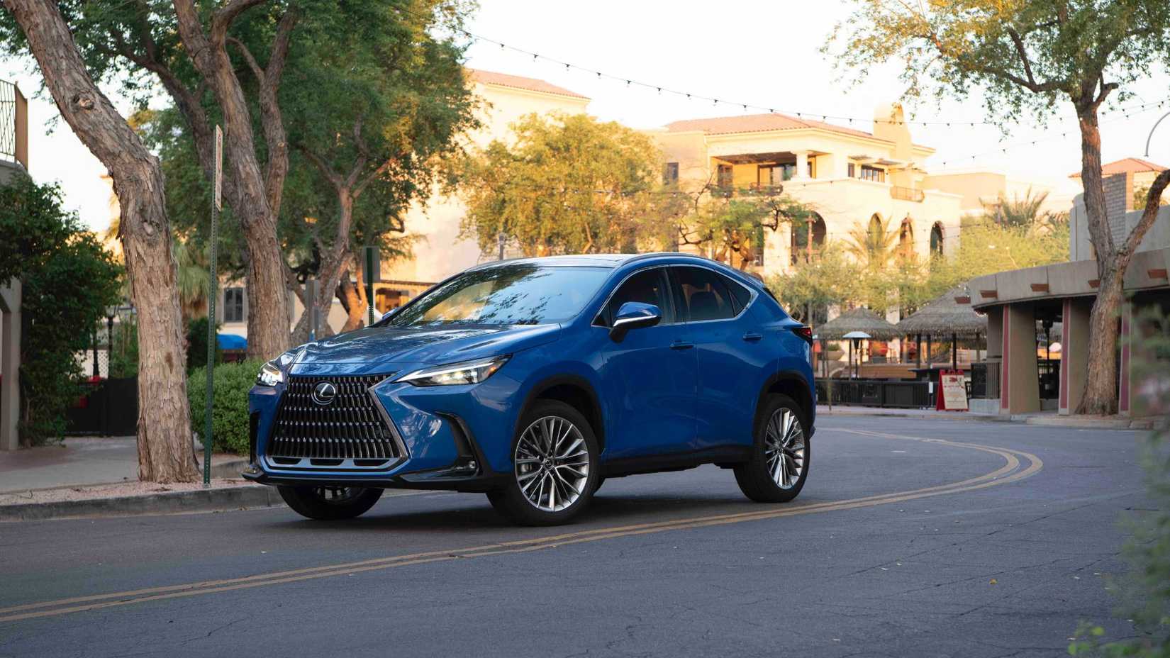 Static front 3/4 shot of a blue 2025 Lexus NX 350h pakred on the bend of a road in a city.