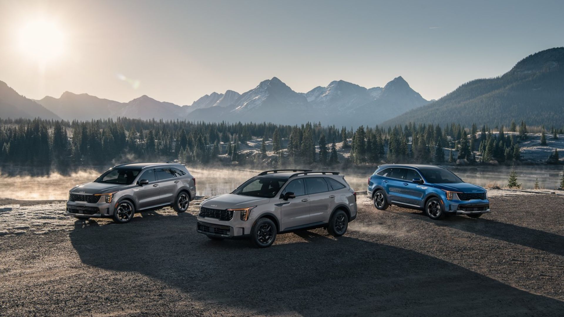 Static shot of the Kia Sorento family lineup with mountains in the background.
