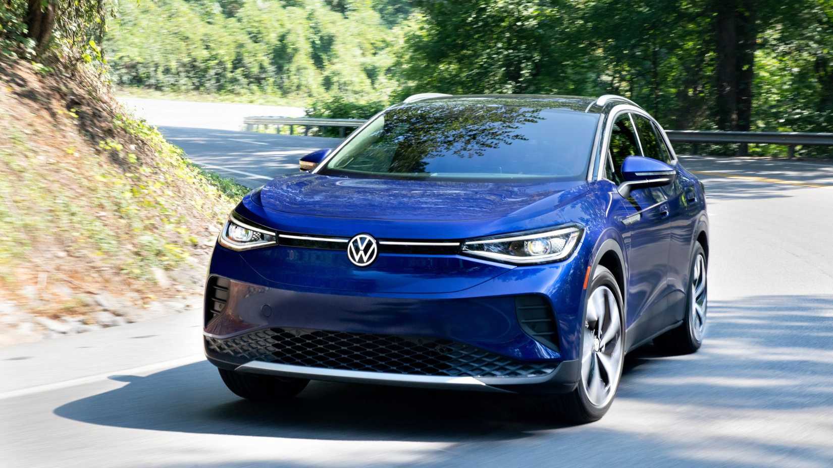 Dynamic front 3/4 shot of a blue 2021 Volkswagen ID.4 driving on a country road.