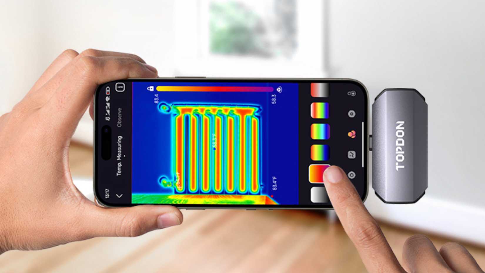 Thermal image camera plugged into a phone USB port.