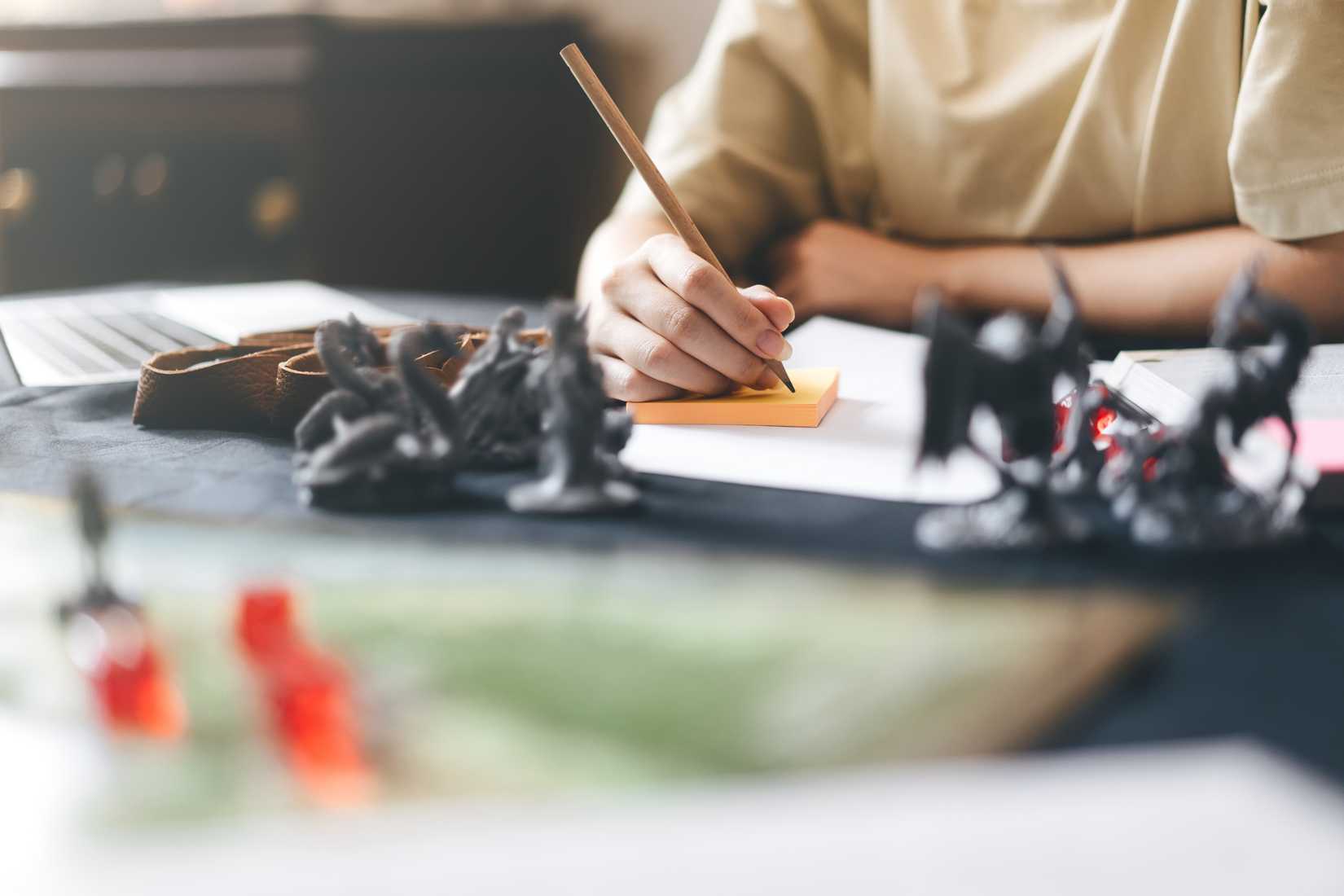 A tabletop RPG player making notes.