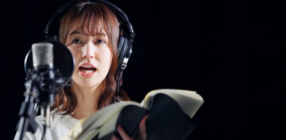 A woman voice actor reads a script.
