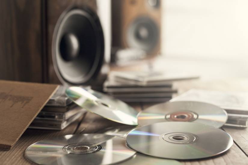 Piles of music CDs with speakers.