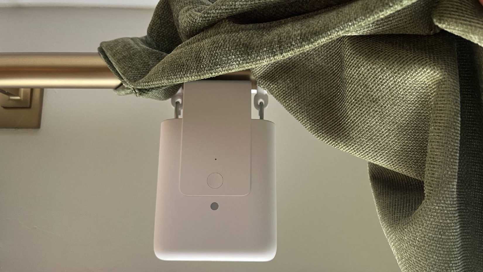 An Aqara Smart Home Curtain Driver on a curtain rod.