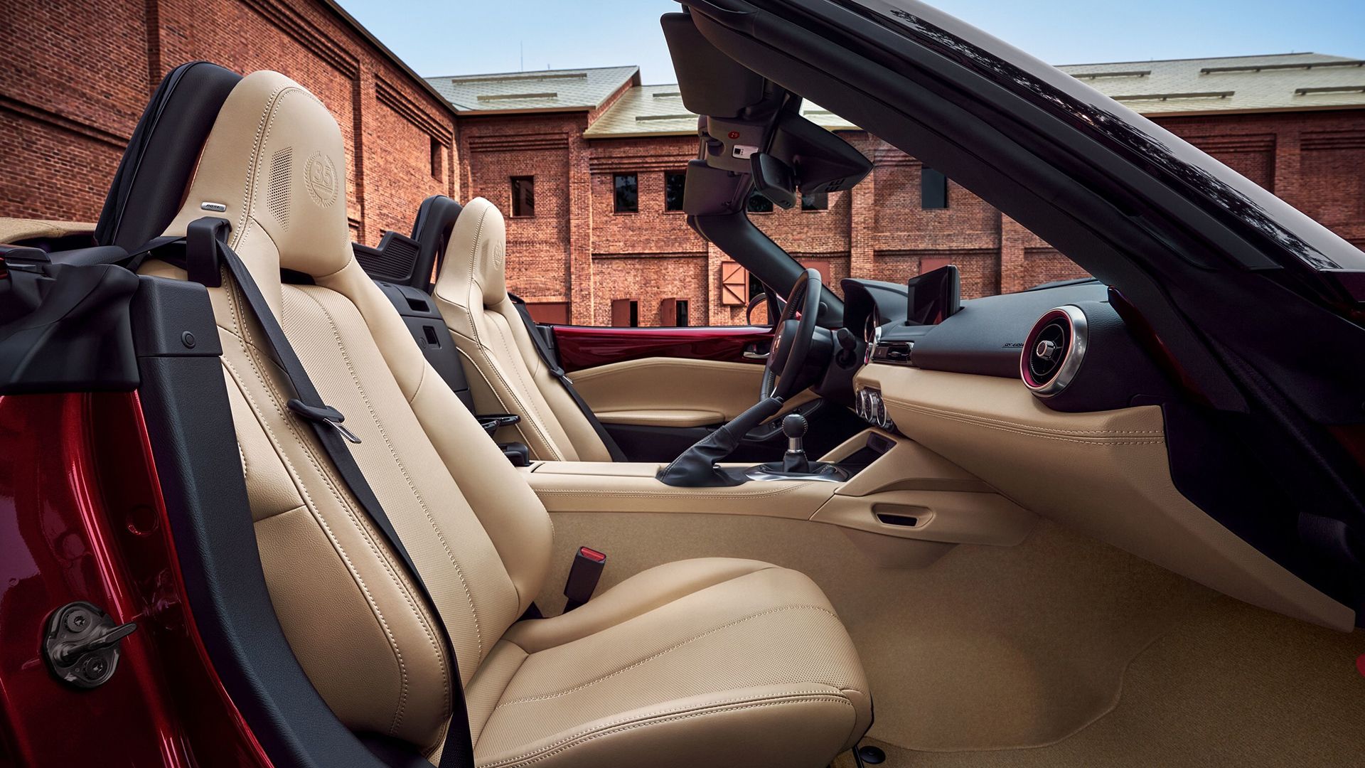 Close-up shot of the interior of a Mazda MX-5 35th Anniversary, showing the driver and passenger seat covered in cream leather.