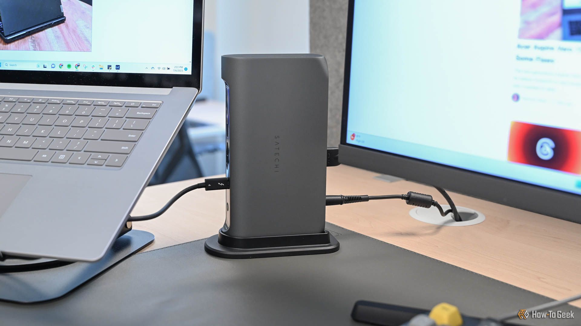 A desk setup with a laptop and monitor plugged into the Satechi Thunderbolt 4 Multimedia Pro Dock.