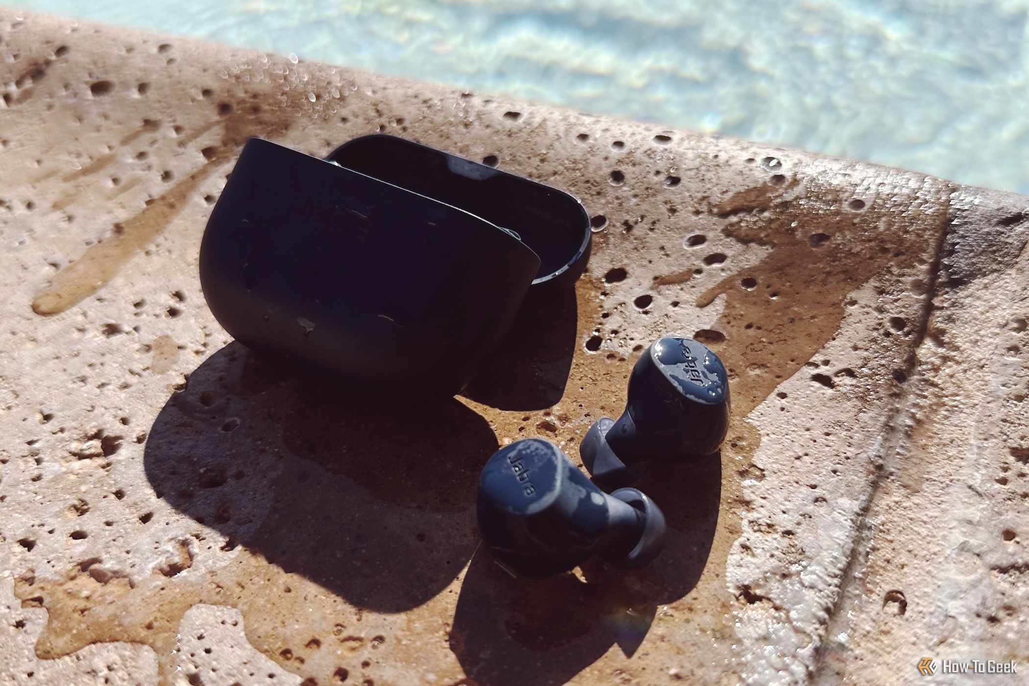 Elite 8 Active earbuds dripping with water from going in a pool
